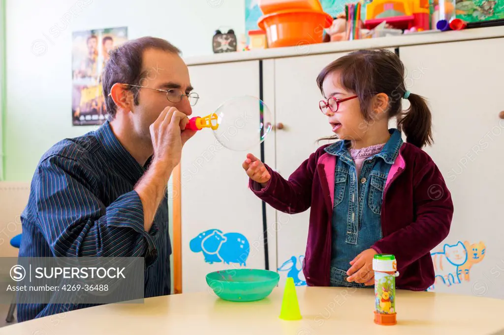 4 year old girl Down's syndrome during a session with a special education teacher.
