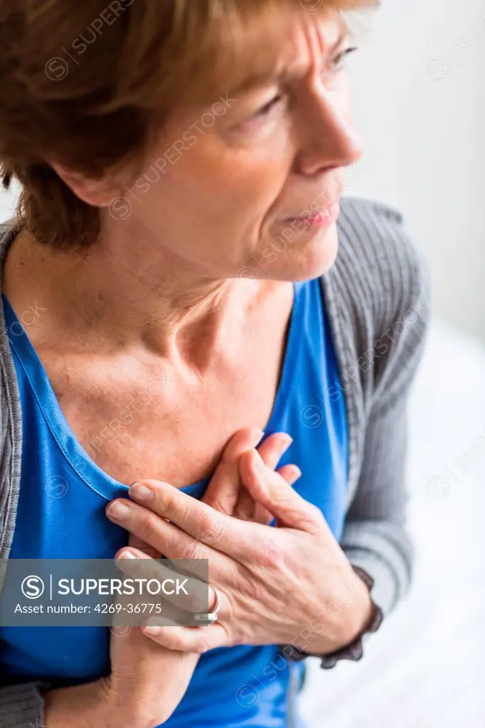 Senior woman clutching her painful chest