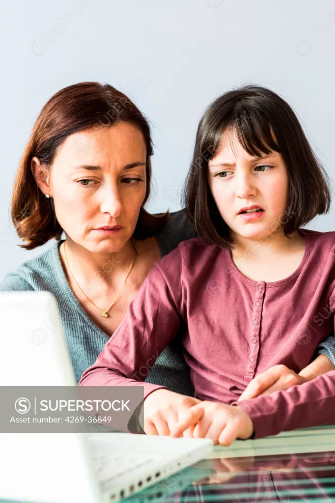 Mother and her 9-year-old daughter using laptop computer