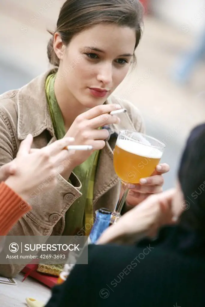 Women smoking and drinking at a terrasse.