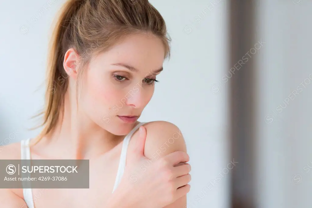 Woman, Shoulder pain. Woman rubbing her shoulder.