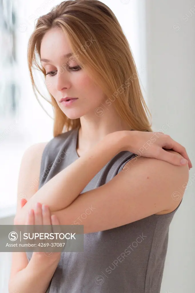 Woman, Woman suffering from a pain in the elbow (tennis elbow).
