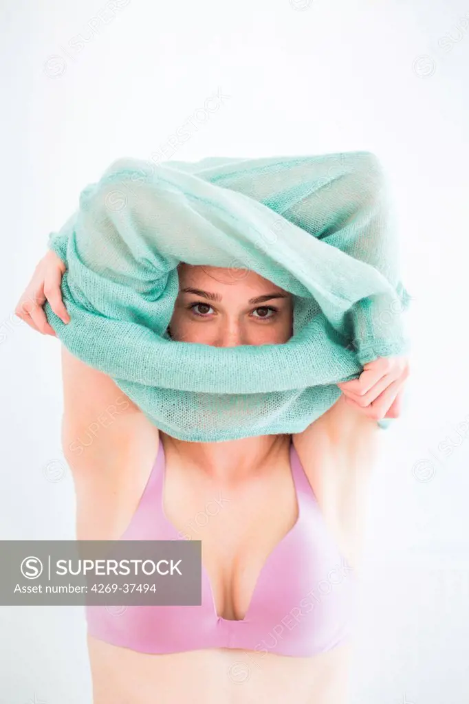 Young woman taking off her sweater.