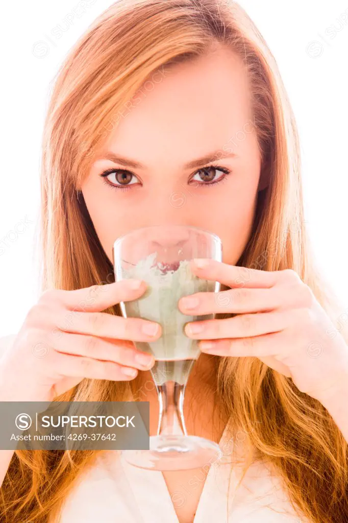Woman drinking green clay.