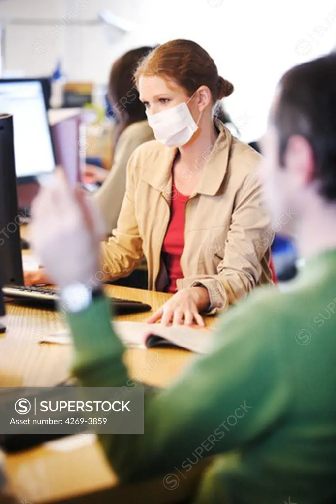 The French Minister of Health recommends the use of a protection mask in case of viral respiratory diseases (common cold, flue, bronchitis) to prevent contagion. Here, a woman wearing a mask at work.