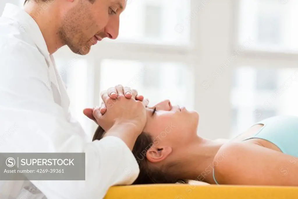 Woman's head being manipulated by an osteopath.