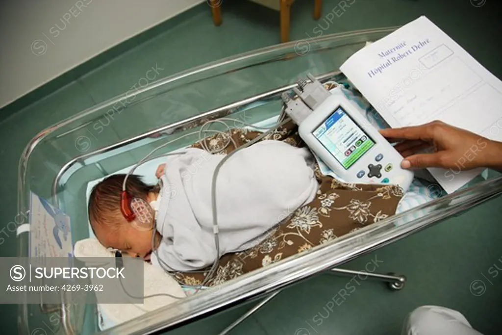 2 years old baby undergoing deafness screening test with the method of the auditory evoked potentials (AEP) which analyzes the electrical activity of the auditory nerve sensed by 3 surface electrods.