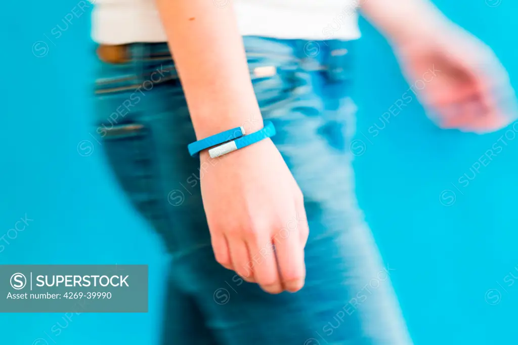 Woman wearing an UP® by Jawbone electronic wristband, sensor tracker.