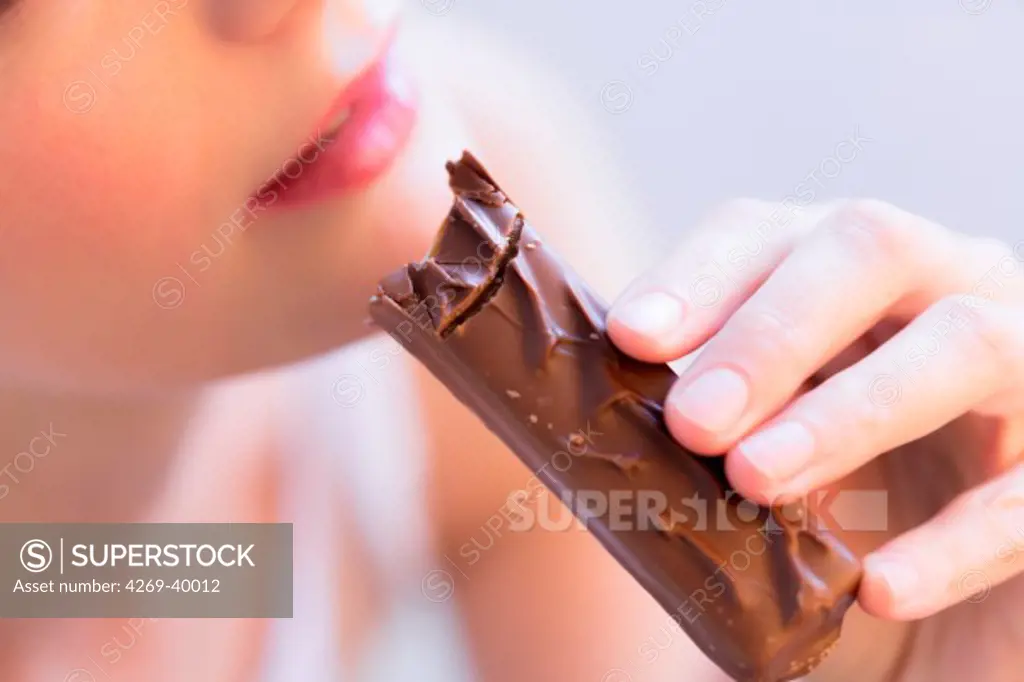 Woman eating a chocolate bar.