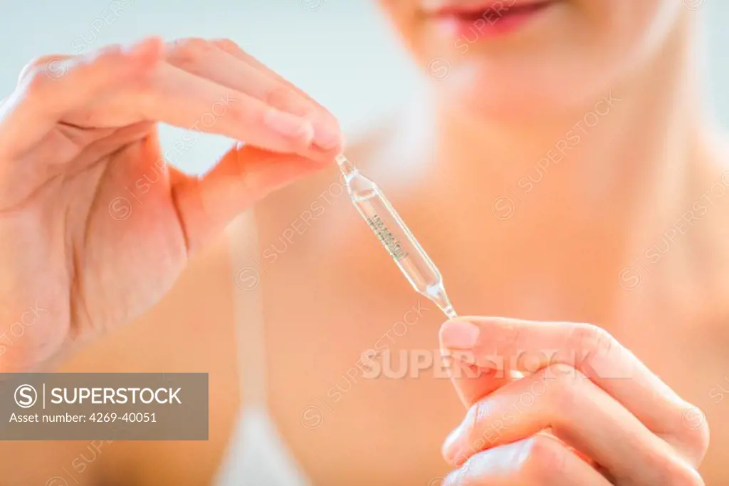 Woman holding glass ampoules of trace elements.