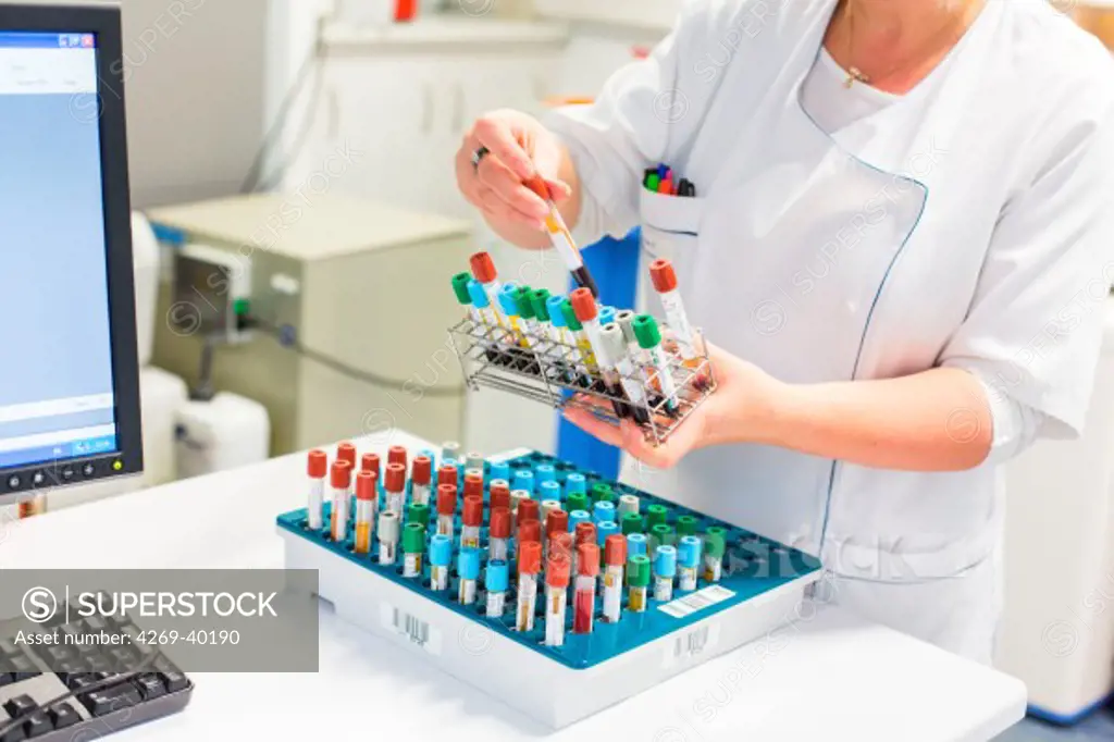 Female technician handling blood samples in a medical laboratory.