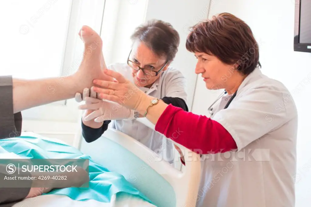 Diabetologist doctor and podiatrist examining the feet of a diabetic patient, Angouleme hospital, France.