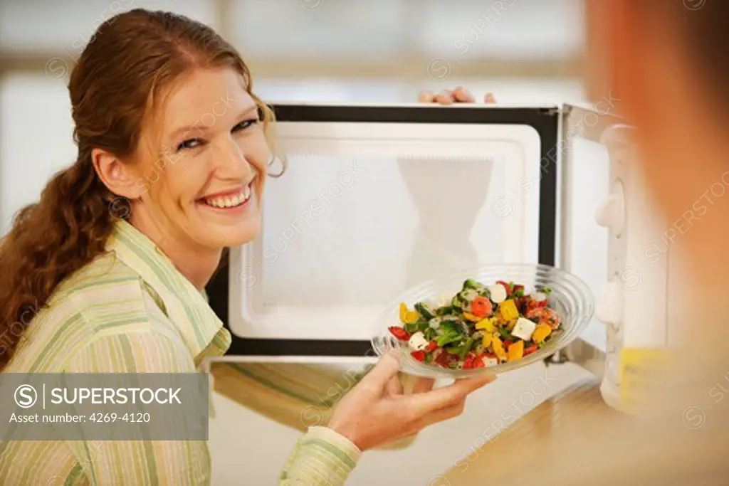 Woman using a microwave oven.
