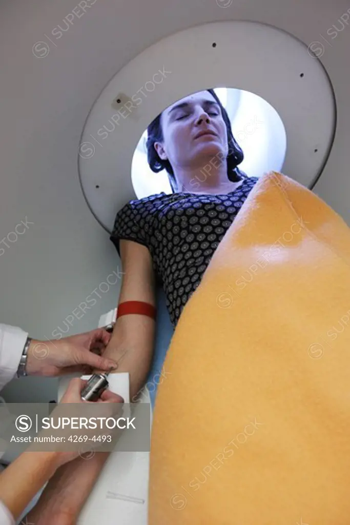 A nurse is injecting a solution of radioactive isotopes to a patient before undergoing a MRI scan (Magnetic Resonance Imaging) examination. The syringe is equiped with a lead shield to protect the technician from radiation.