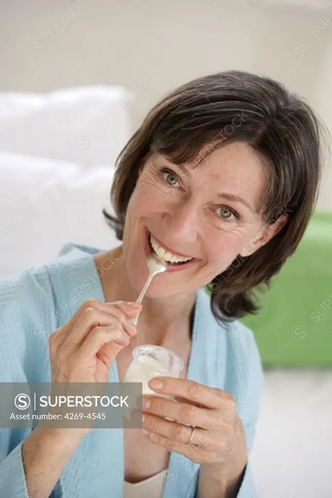 Woman eating a yogurt.