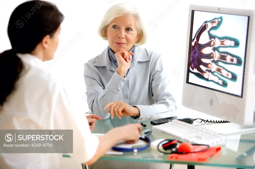 Doctor discussing hand X-ray with a patient.