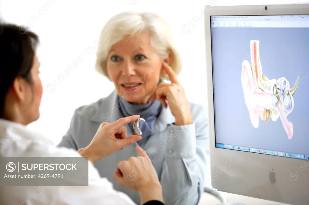Hearing aid specialist explaining a patient the use of digital hearing aid.