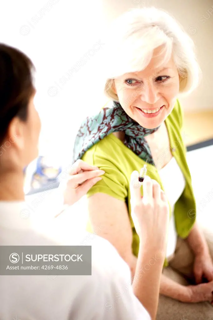 Elerdly woman receiving vaccination against influenza.