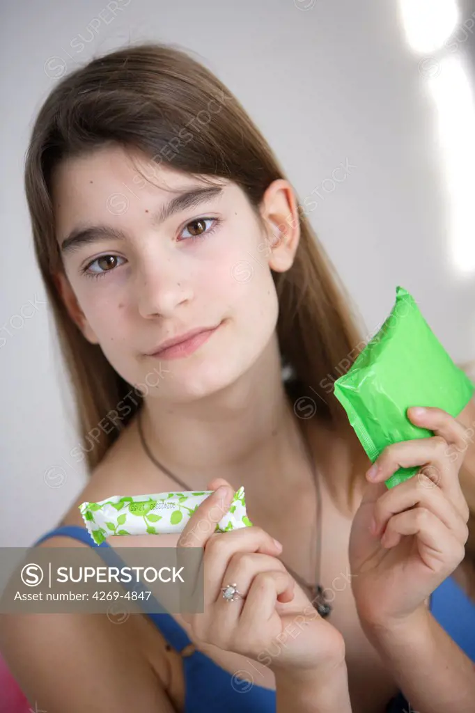 Teenage girl with tampon and sanitary napkin.