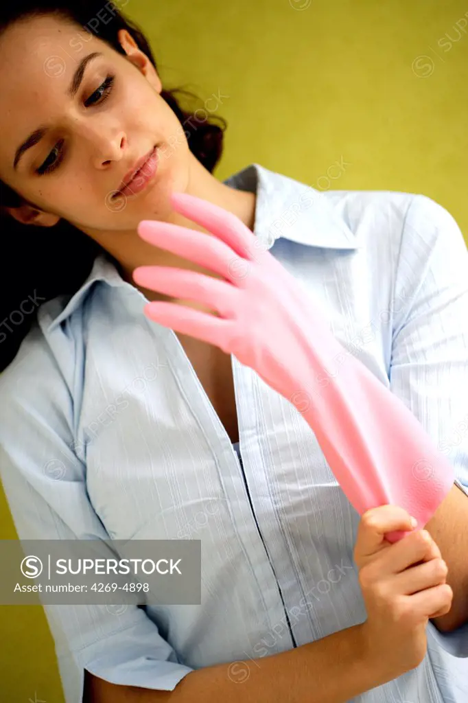 Woman putting on cleaning gloves.