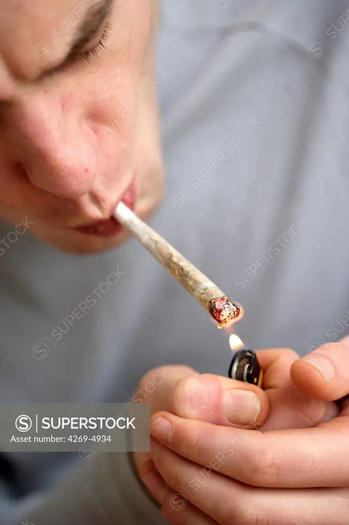 Man smoking marijuana or hashish cigarette.