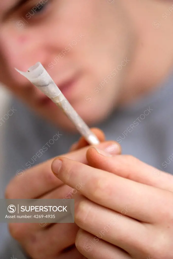 Man smoking marijuana or hashish cigarette.