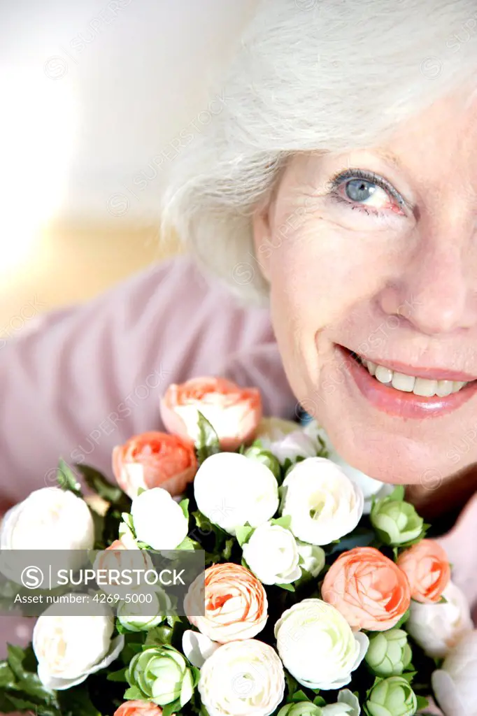 Elderly woman with bunch of flowers.
