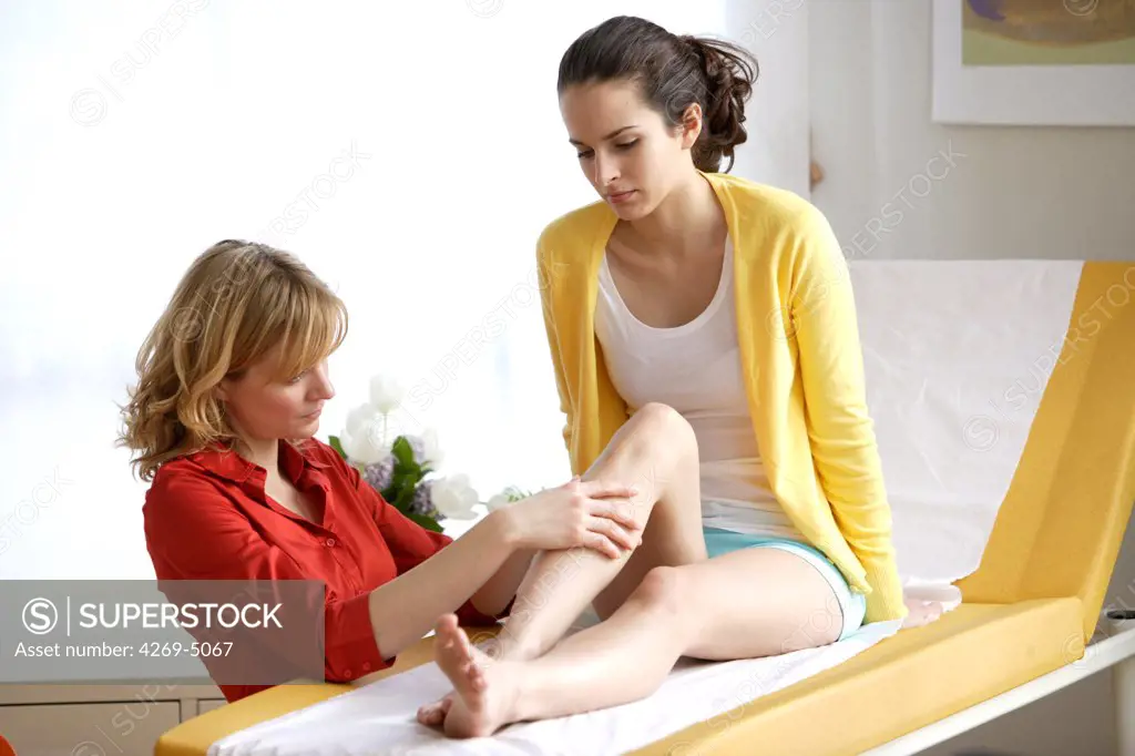 Doctor examining the legs of a patient.