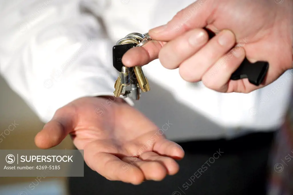 Hands passing on keys.
