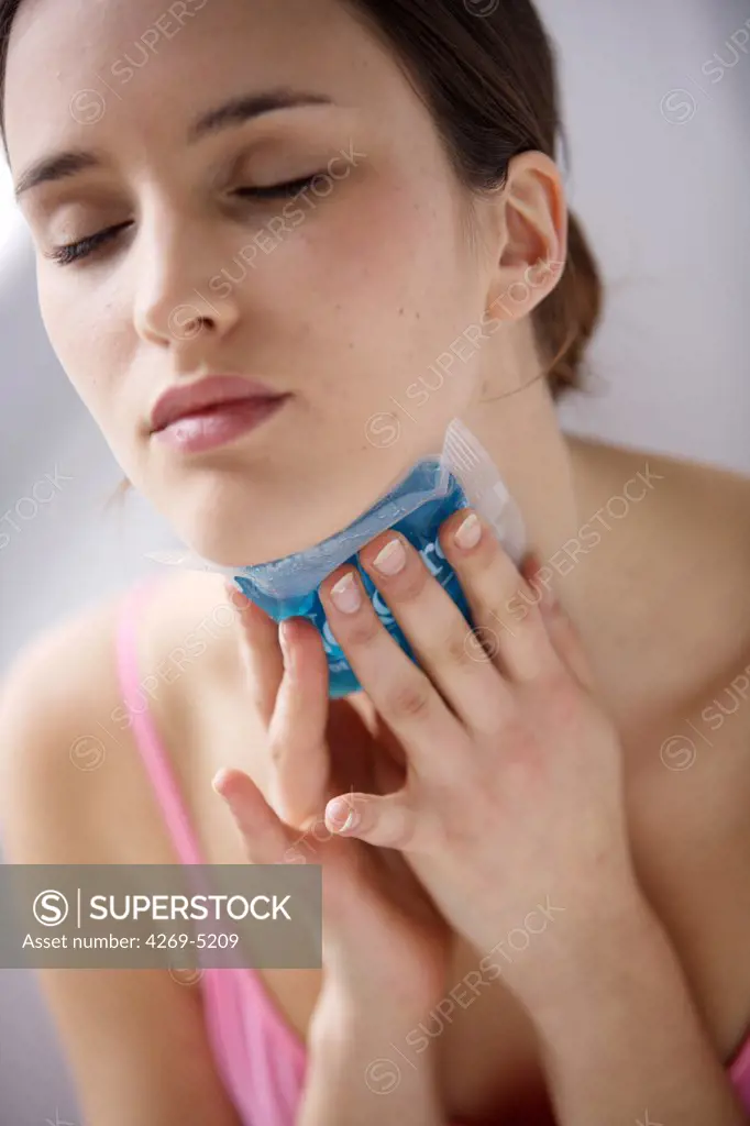Woman using a hot-cold gel pack treatment to releive pain.