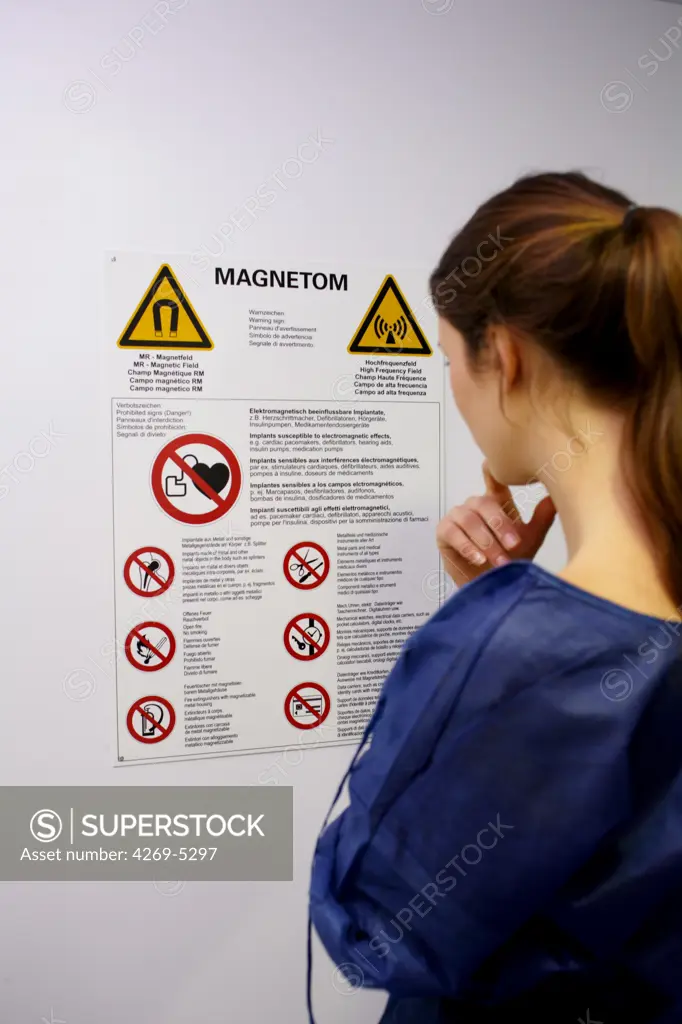 Patient reading warning instructions posted on the MRI (Magnetic Resonance Imaging) scan room in hospital.