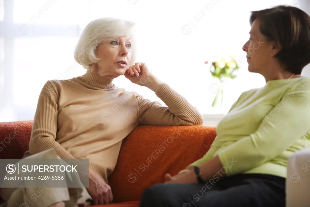 Woman and elderly woman talking at home.