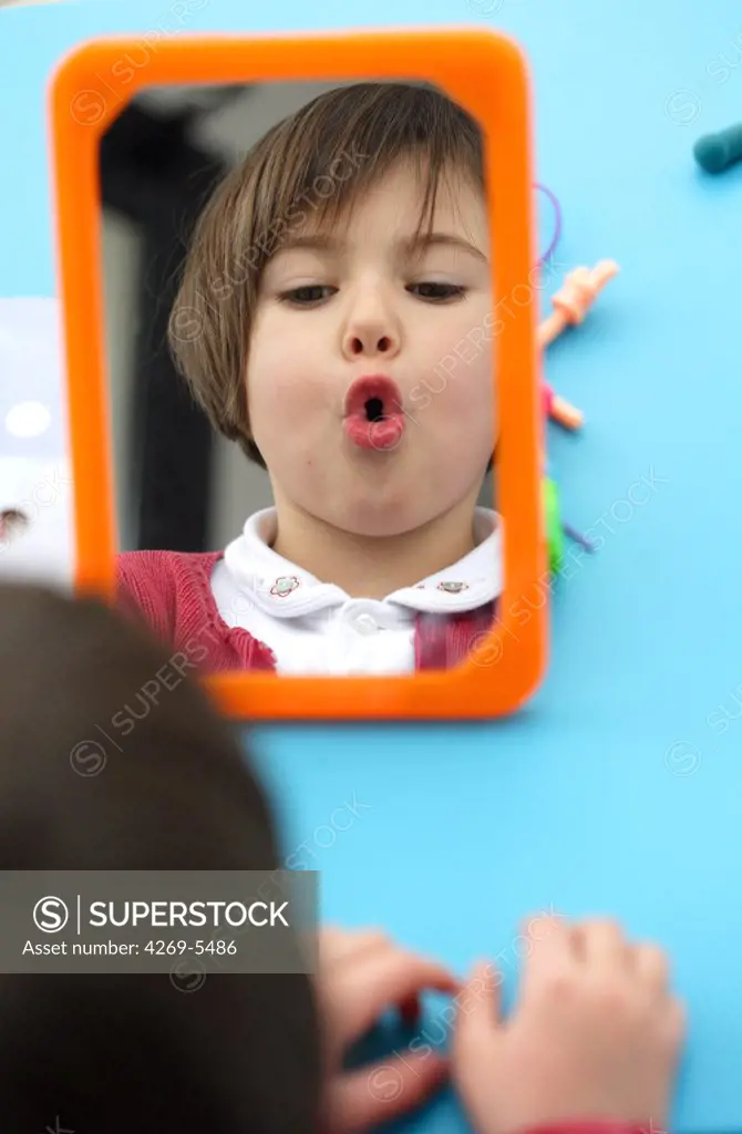 5 years old girl during speech therapy cession.