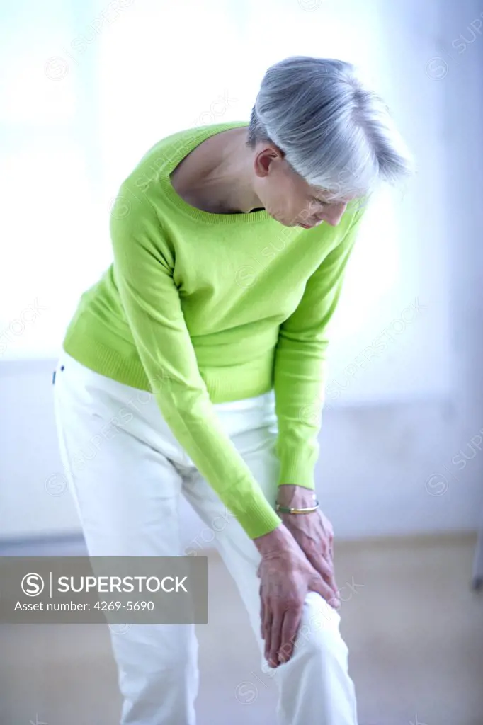 Senior woman suffering from a pain in the knee.