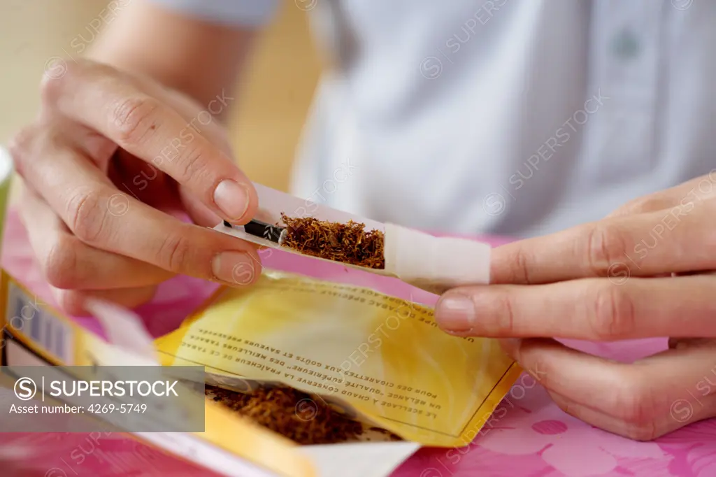 Teenager rolling a joint.