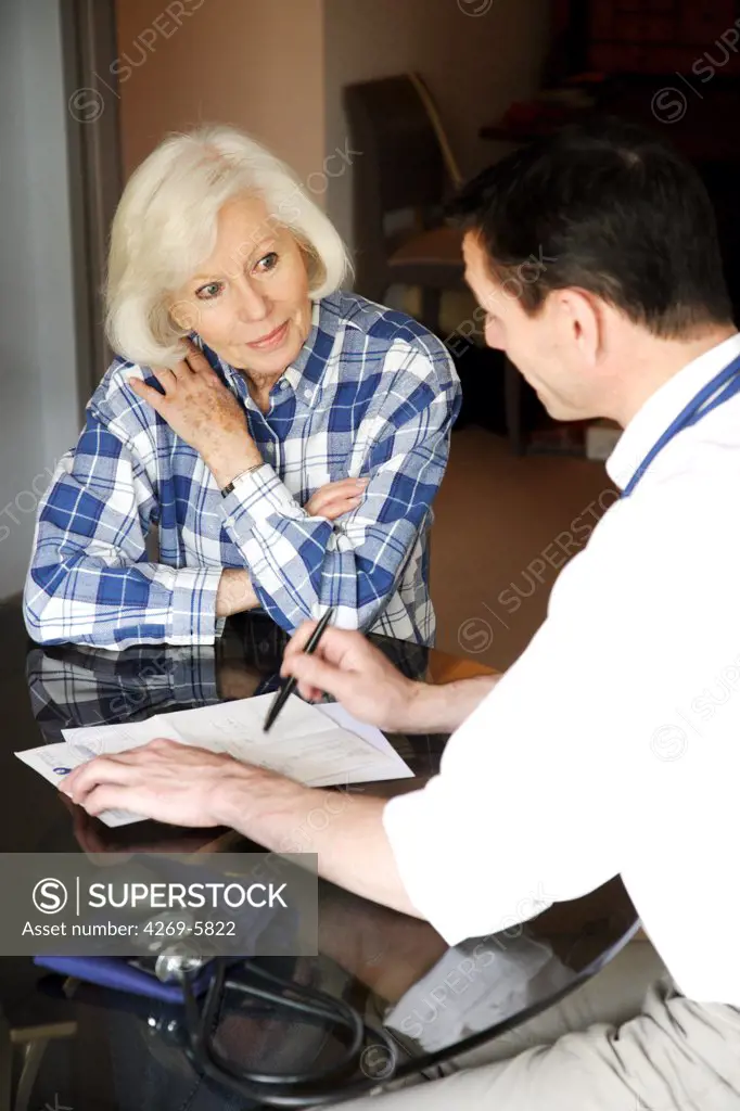 General practitioner writing a medical prescription after home visit.