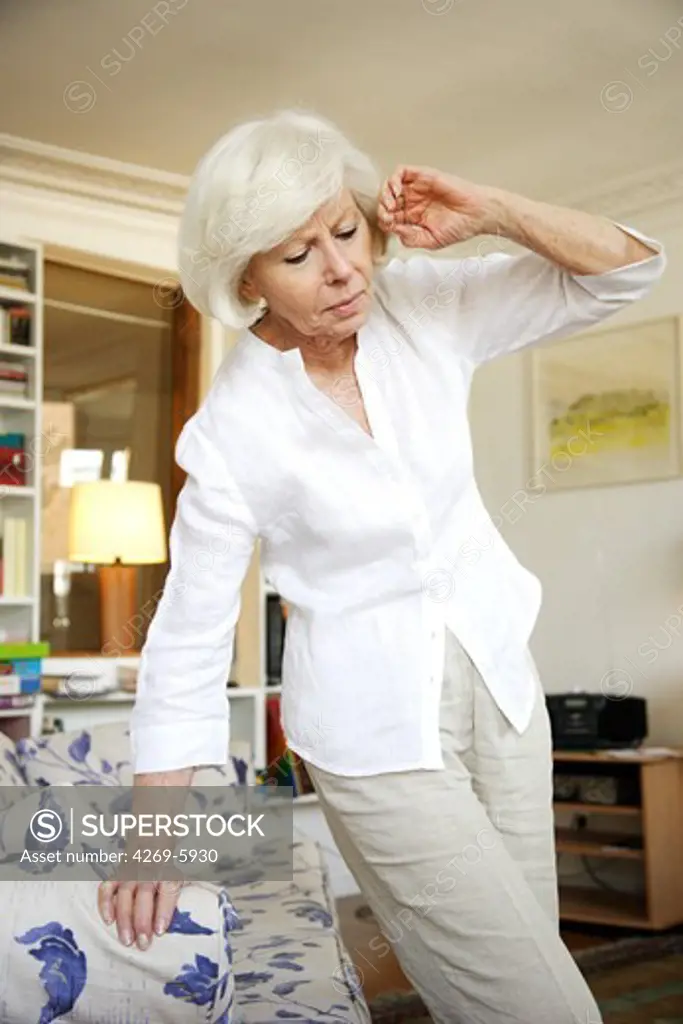 Elderly woman experiencing about of dizziness or feeling faint.
