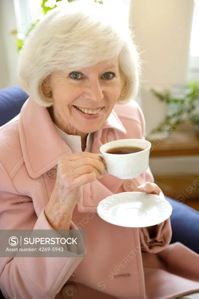 Elderly woman drinking coffe.
