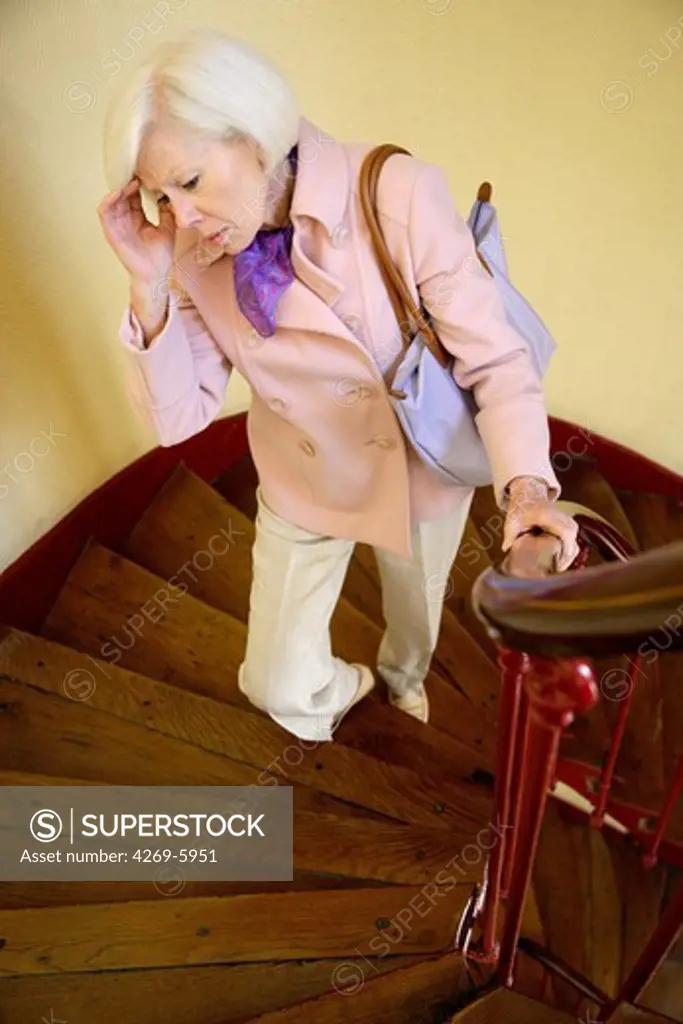 Elderly woman climbing up the stairs.