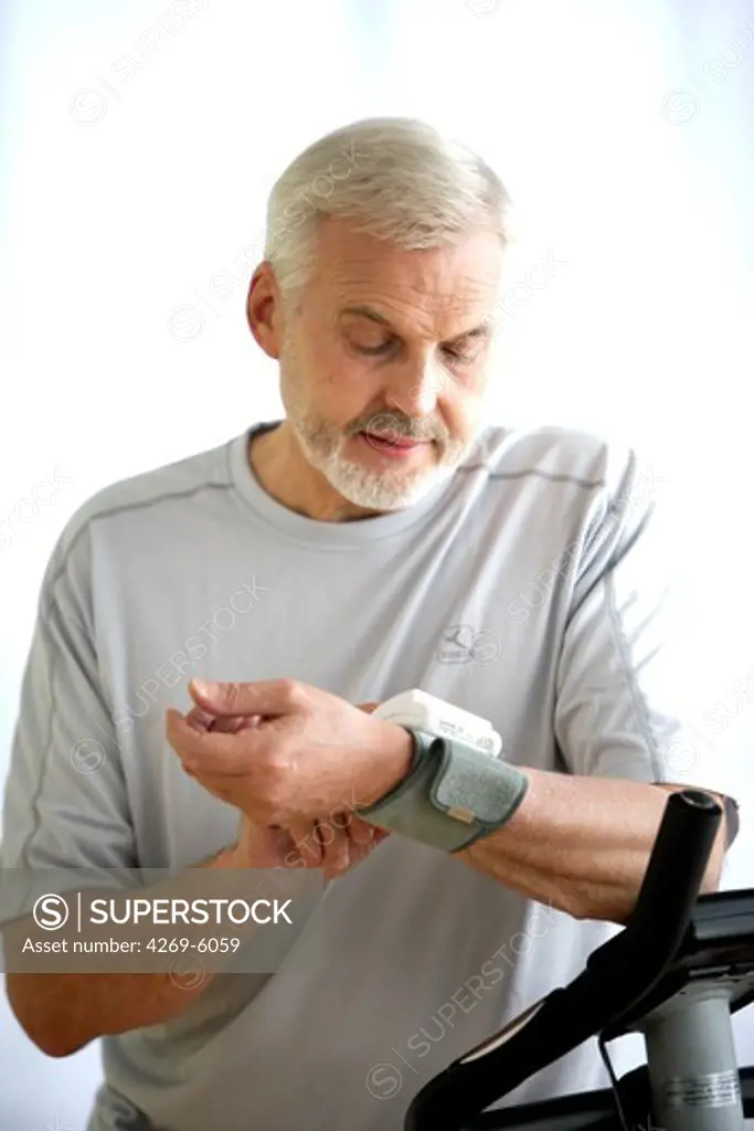 Man taking his blood pressure with a portable blood pressure monitor after physical activity.