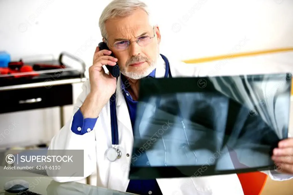 Doctor commenting X-rays on the phone.