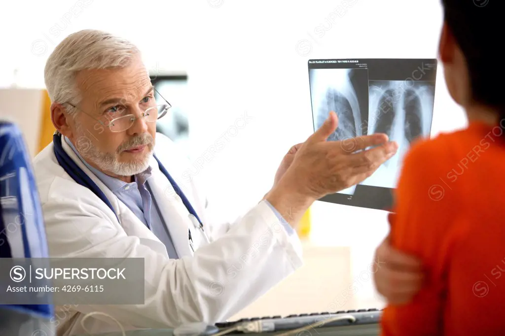Hospital doctor commenting on lungs X-ray of a patient.