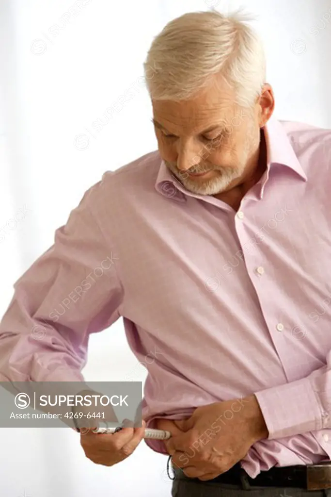 Man giving himself an insulin injection with an insulin pen to treat diabetes.