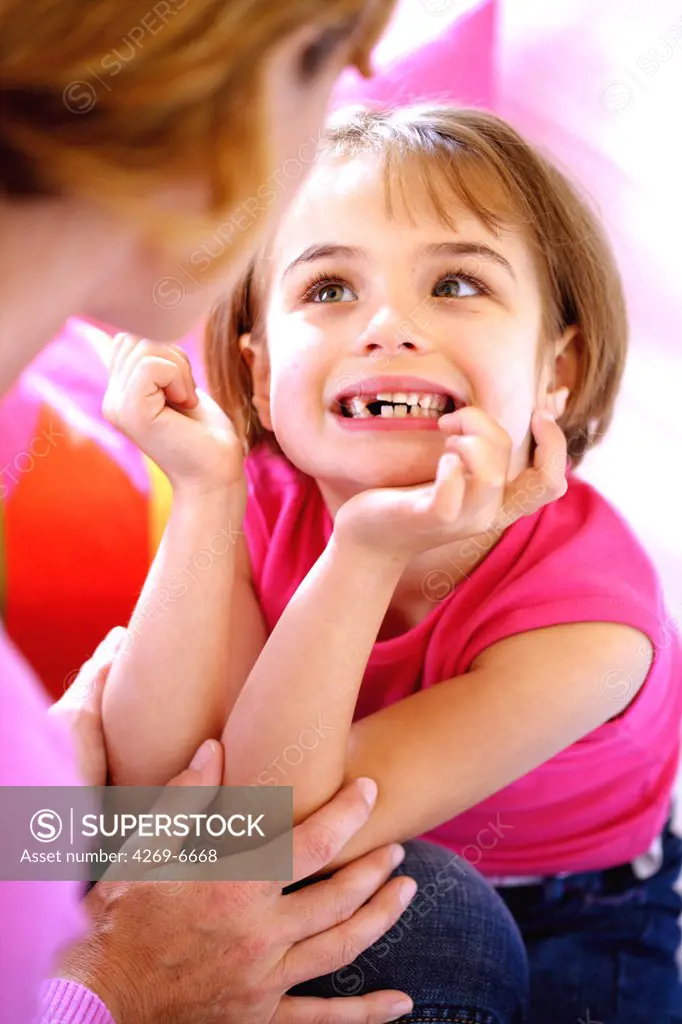6 years old girl showing her milk teeth.