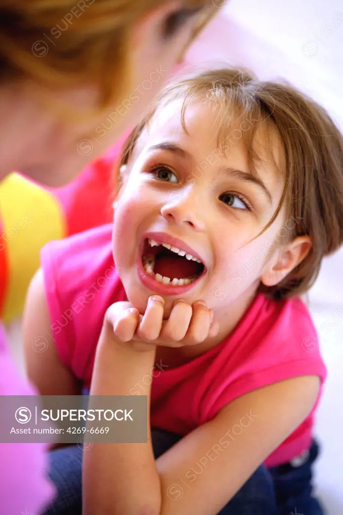 6 years old girl showing her milk teeth.