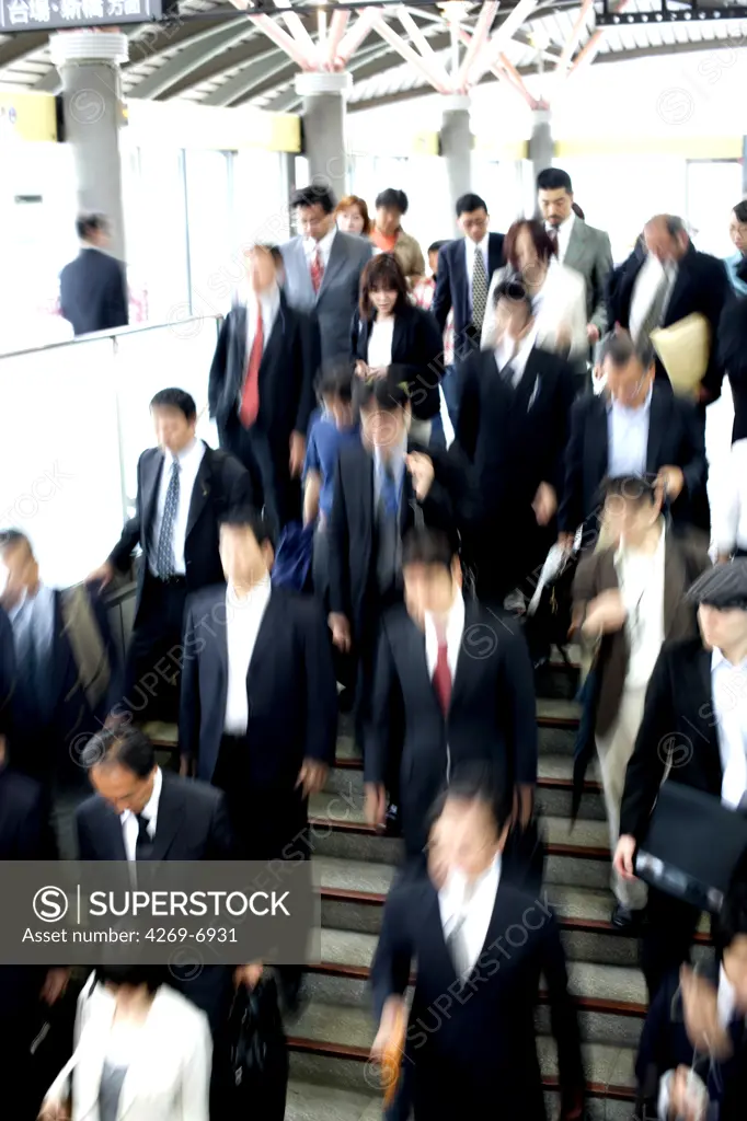 Businessmen in public transport, Tokyo, Japan.
