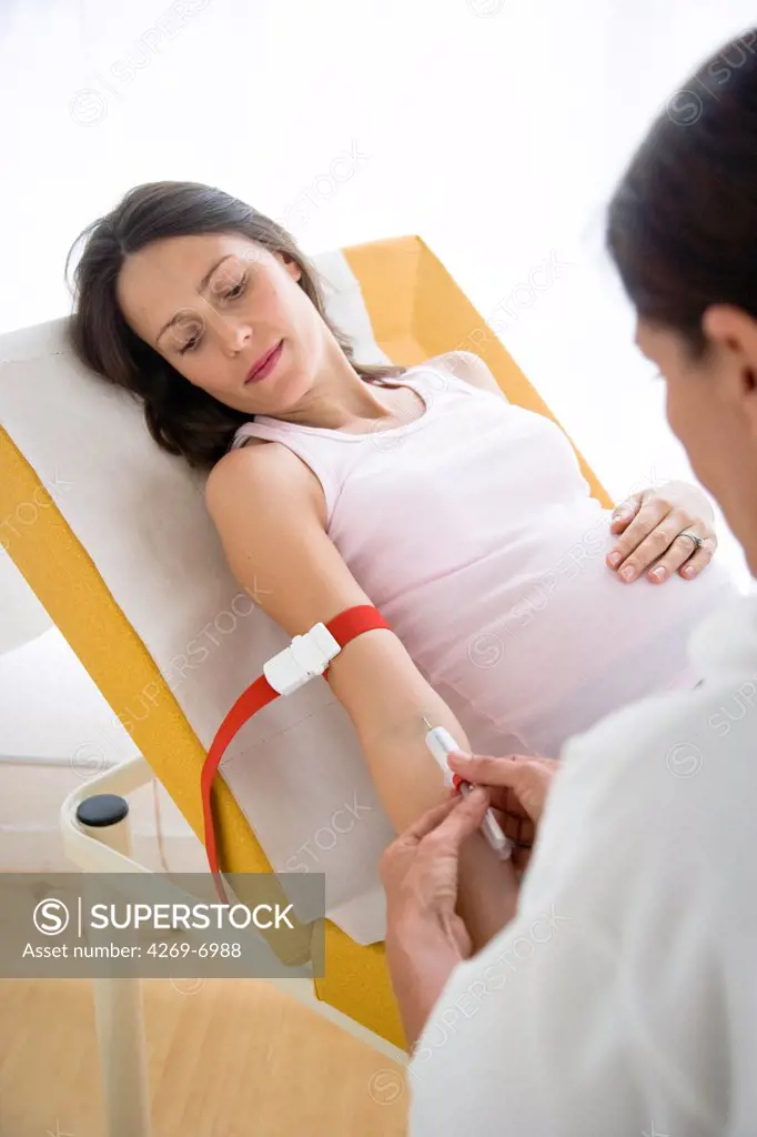 Doctor taking a blood sample from a pregnant woman.