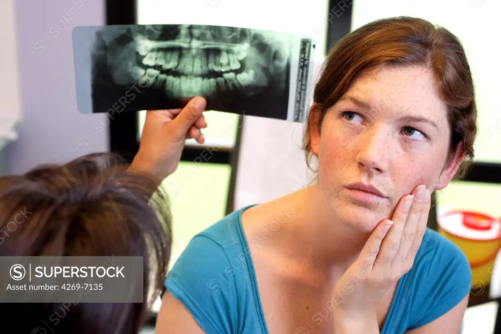 Orthodontist examining a 13 years old teenager's panoramic X-ray.
