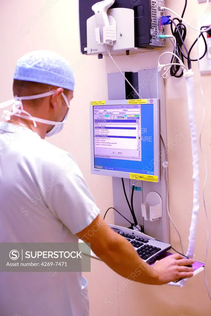 Anaesthetist checking anaesthetic monitoring datas during surgery. Department of gastroenterological surgery, Limoges hospital, France.