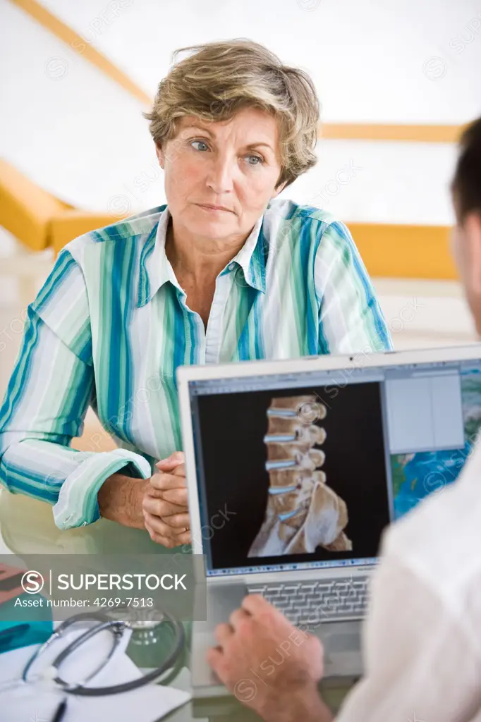 Doctor discussing backbone 3D CT scan with a patient.